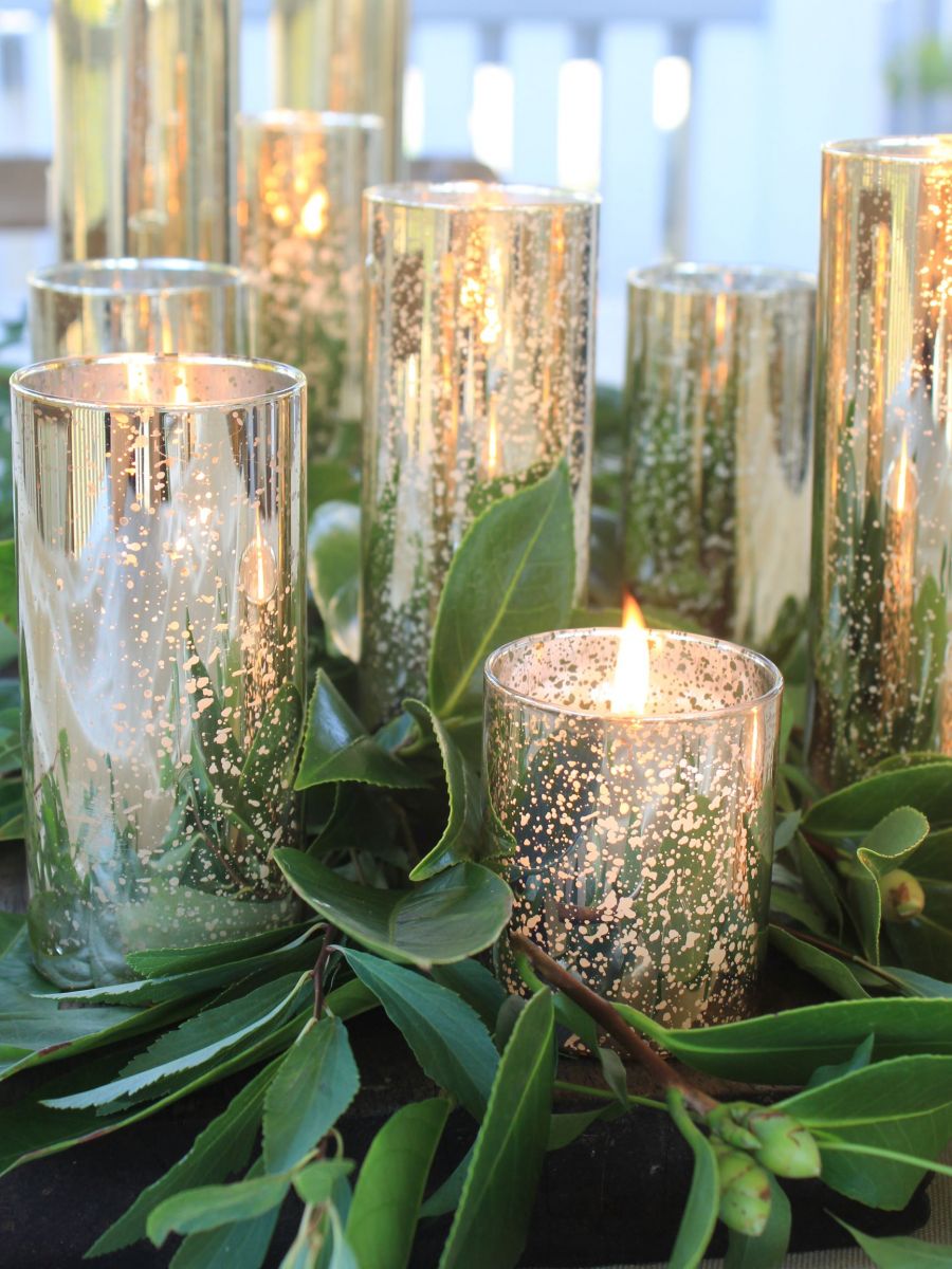 image of gold candle holders with flickering flame on outdoor dining table
